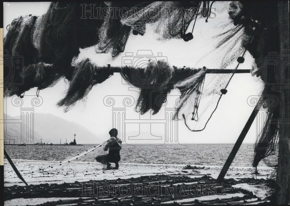 1969 Press Photo Greek boy helps fisherman father with net. - Historic Images