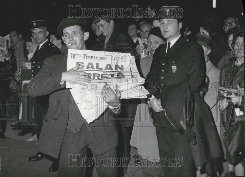 1962 Press Photo Man Selling Newspapers Detailing General Salan's Arrest-Historic Images