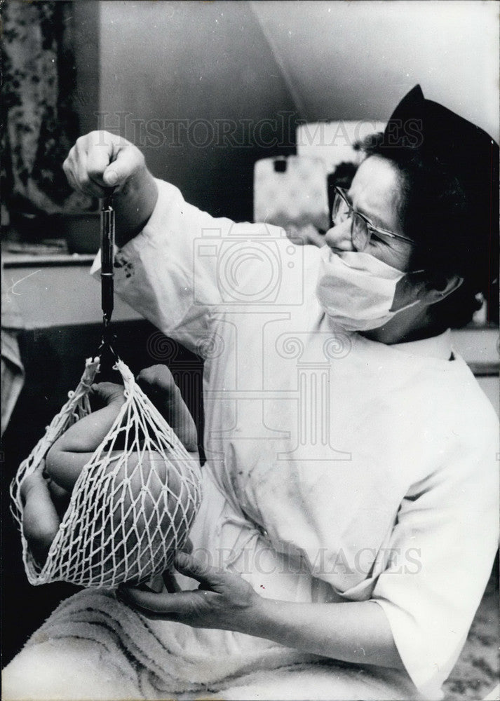 1968, Nurse weighs baby at German Hospital. - Historic Images