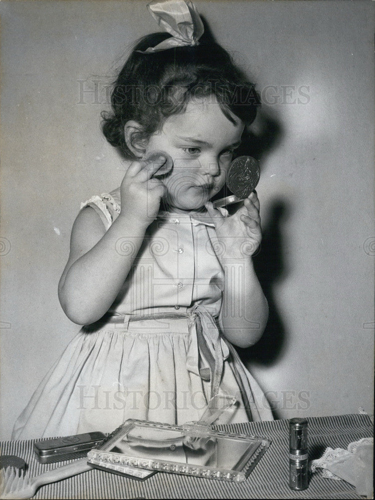 Little Girl Putting on Rouge. - Historic Images