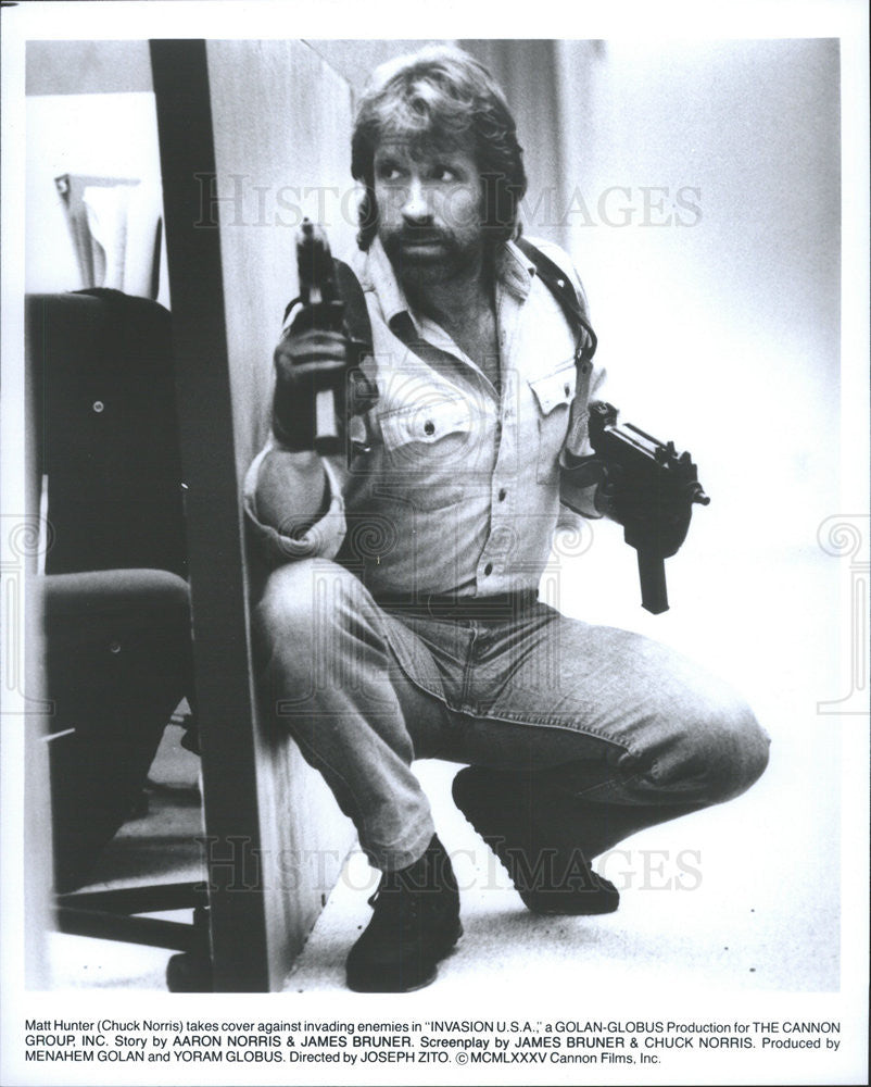 1985 Press Photo Invasion USA Film Actor Chuck Norris Crouching With Guns Scene - Historic Images