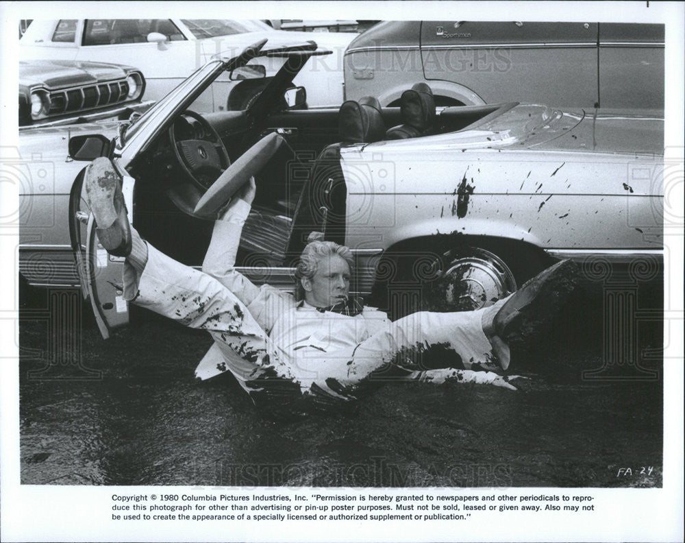 1980 Press Photo Columbia Pictures Film Man Falling Out of Car Mud Puddle - Historic Images