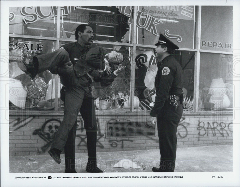 1985 Press Photo movie actors police officers carry man - Historic Images