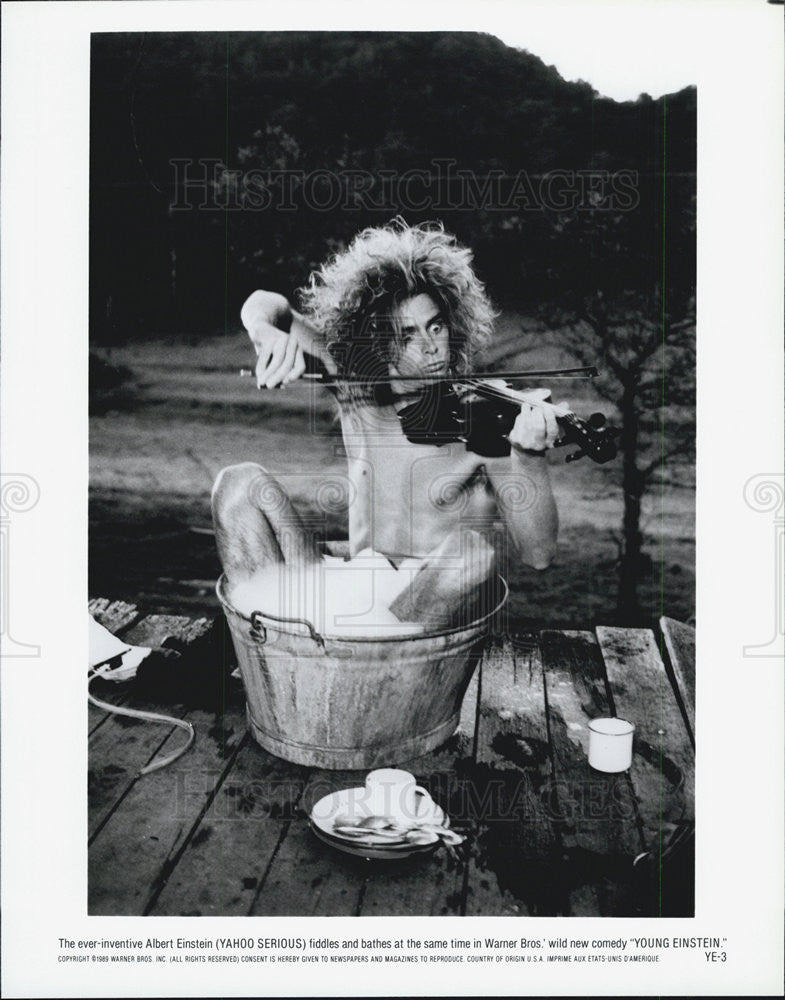 1989 Press Photo Yahoo Serious fiddles and bathes in &quot;Young Einstein.&quot; - Historic Images