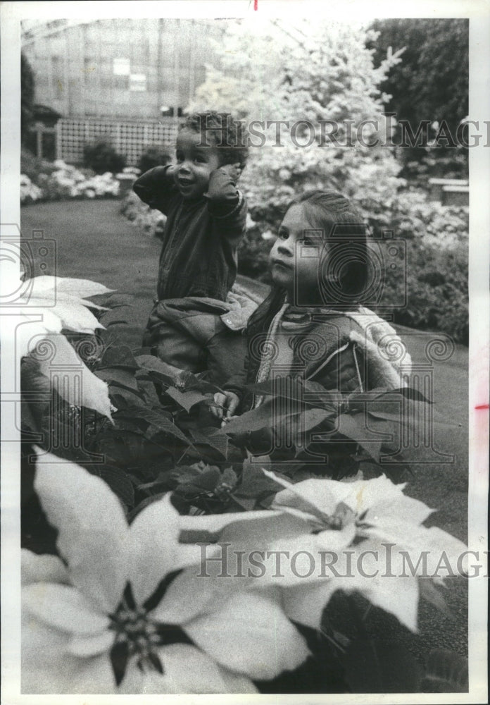 1977 Girl Smelling Flowers Poinsettia - Historic Images