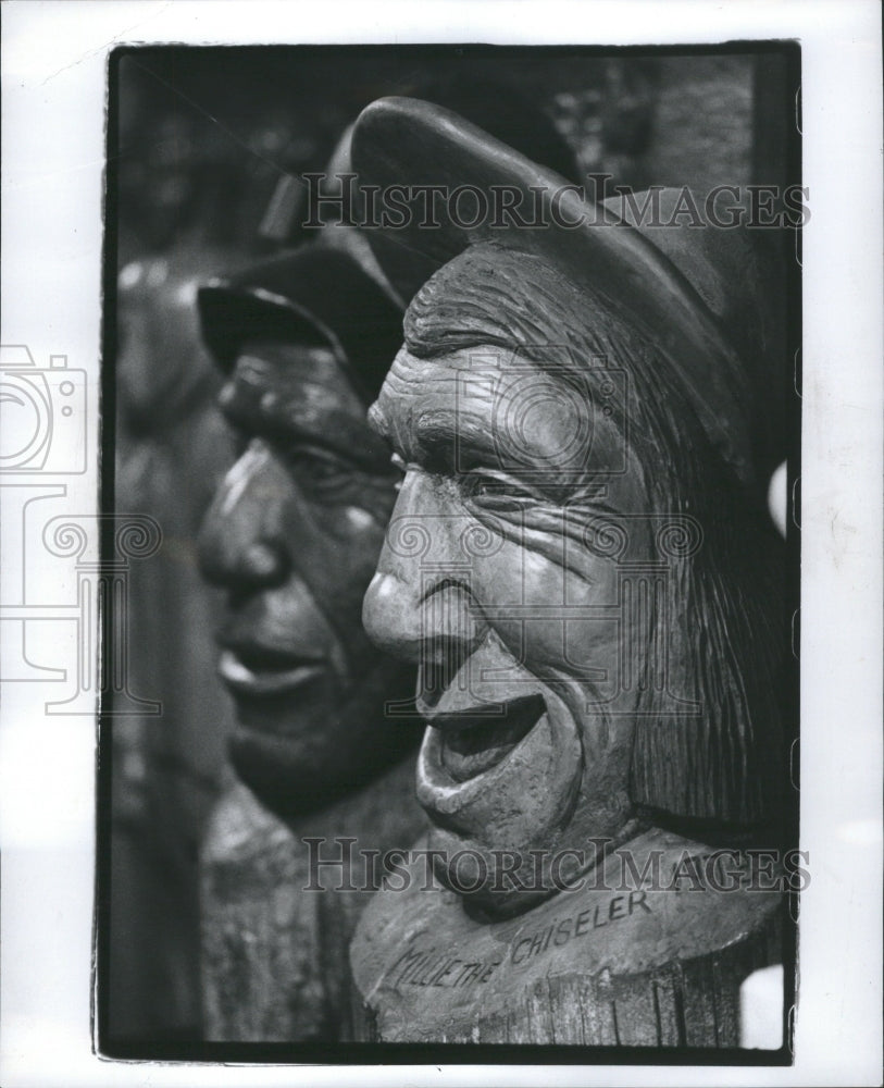 1948 Press Photo Wood Carving Face Statues Hat Carved - Historic Images