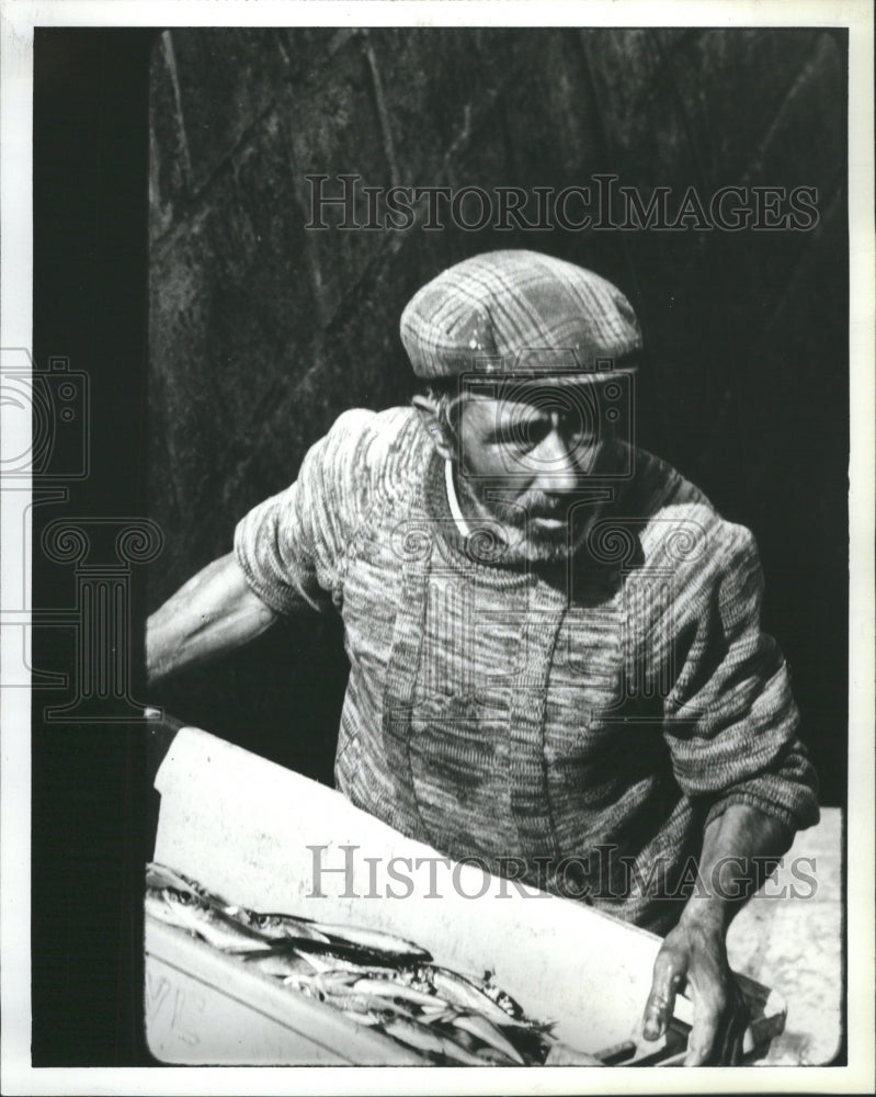 1987 Portugal resident with fish bucket. - Historic Images