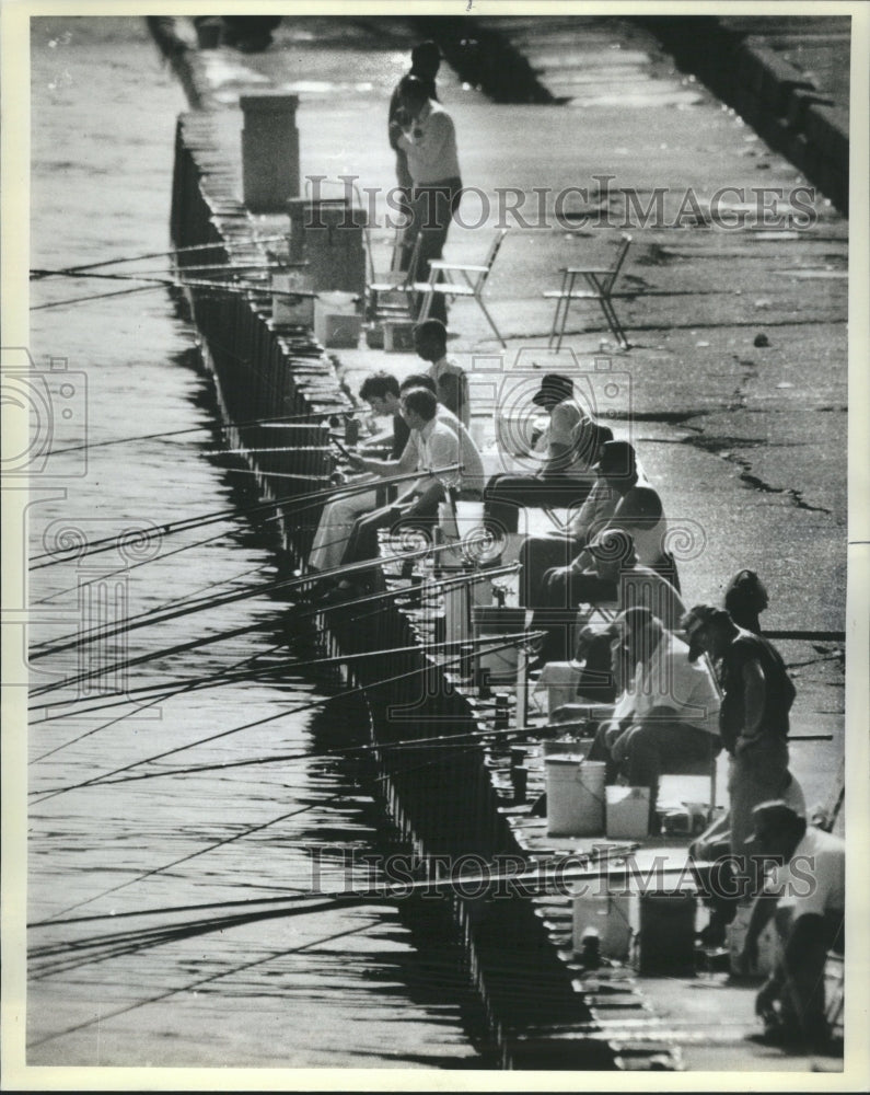 1984 Fisherman line the edge - Historic Images