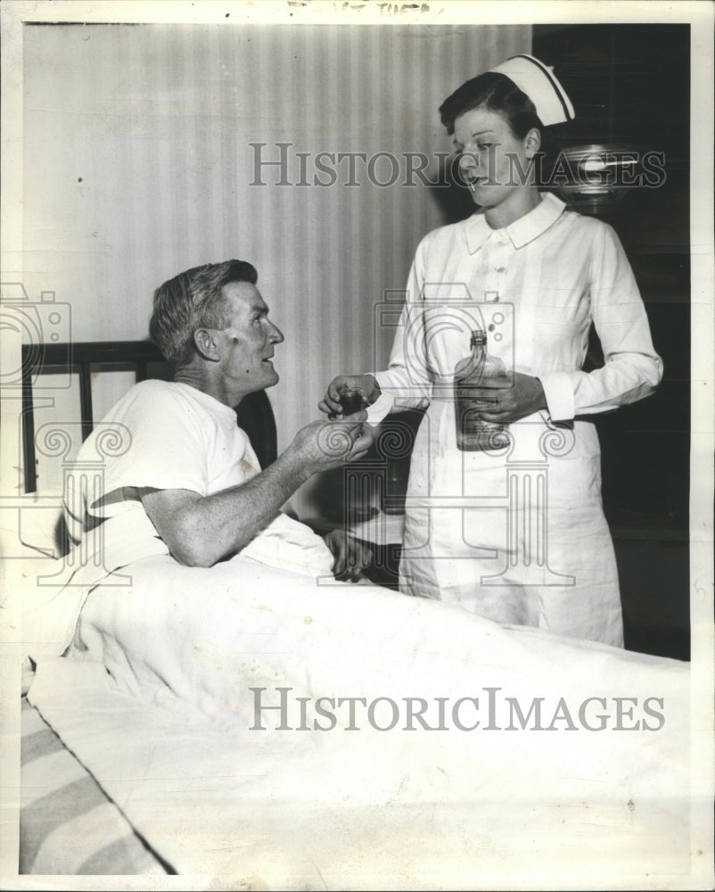 1937 Nurese giving a patient a drink. - Historic Images