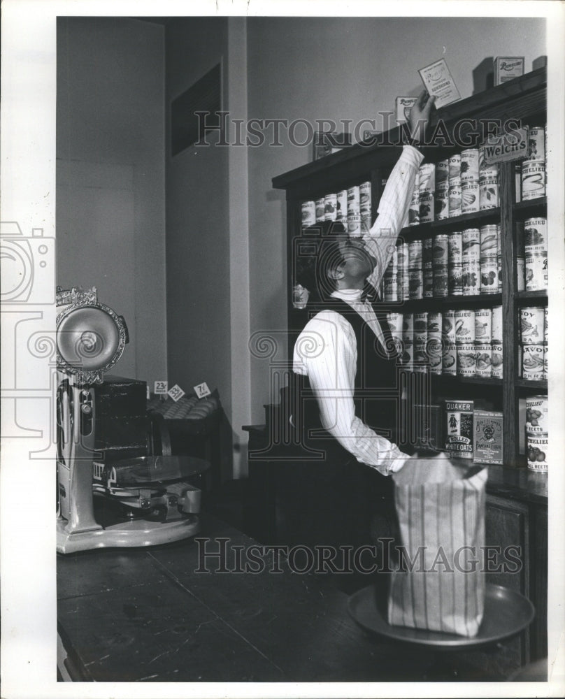 1968 Storekeeper stacks store with supplies - Historic Images