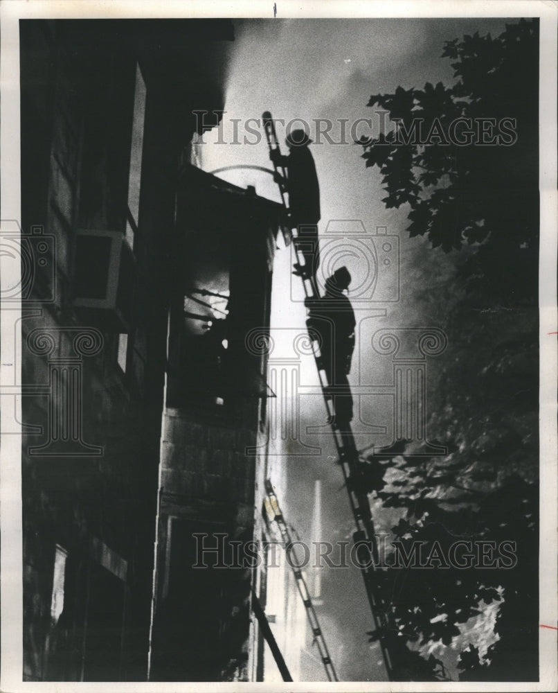 1977 Fireman are Silhouetted Against Flames - Historic Images