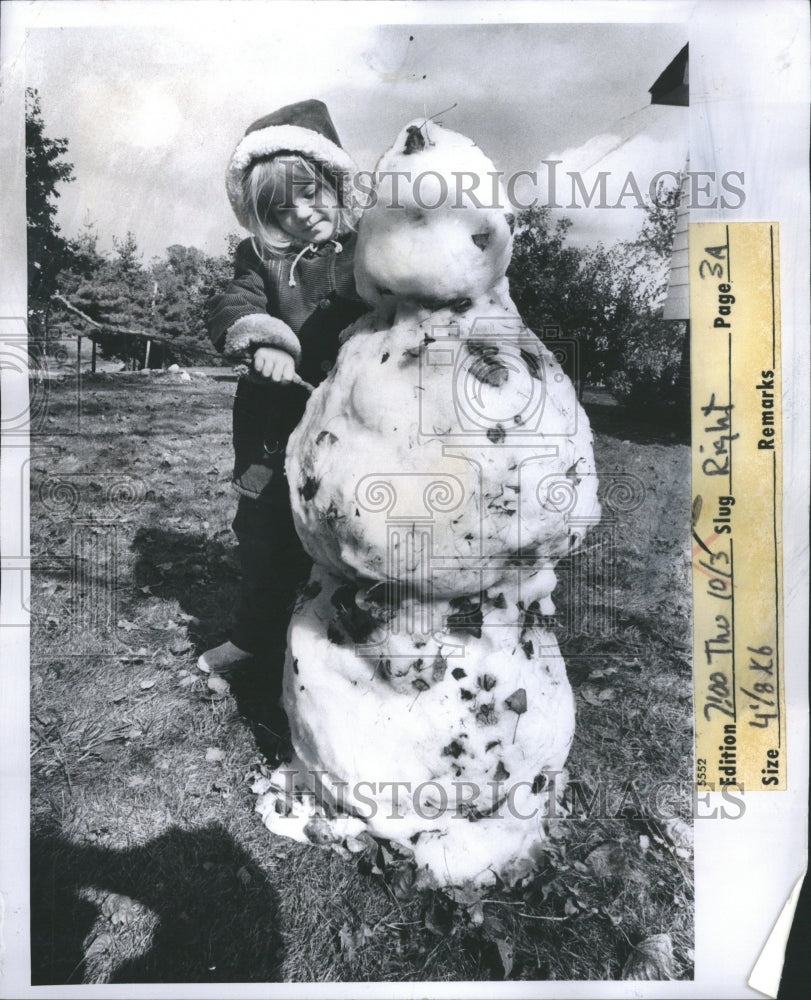 1974 Little girl making snowman - Historic Images