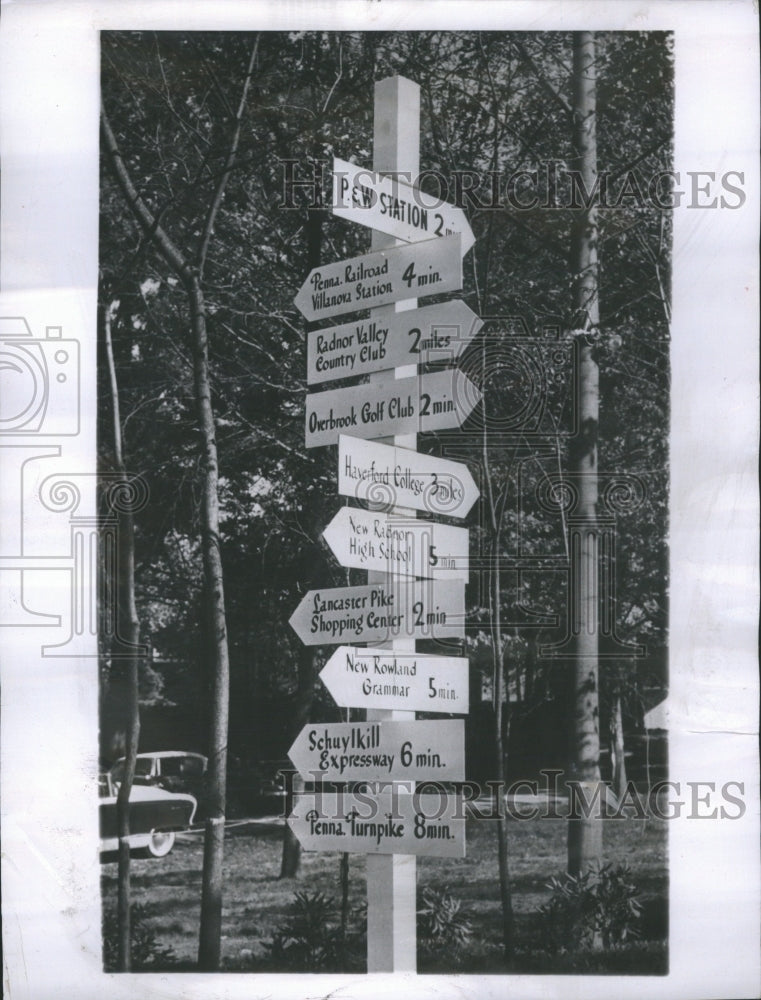 1957 totem pole signpost giving distance - Historic Images