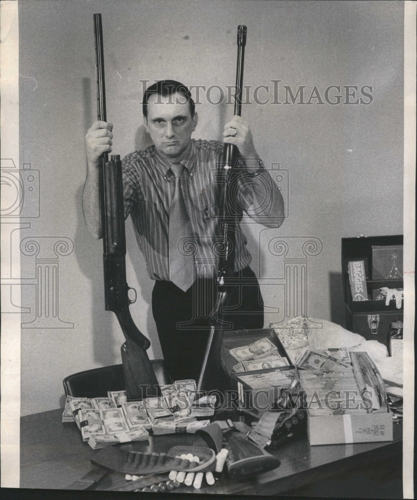1971 Al Pringle showing items after raid - Historic Images