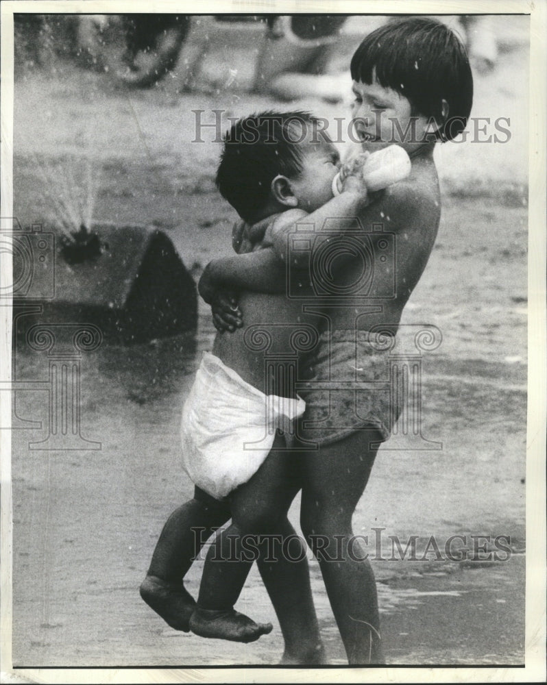 1982 Marquette Kiddie Pool Kid Carries Baby - Historic Images