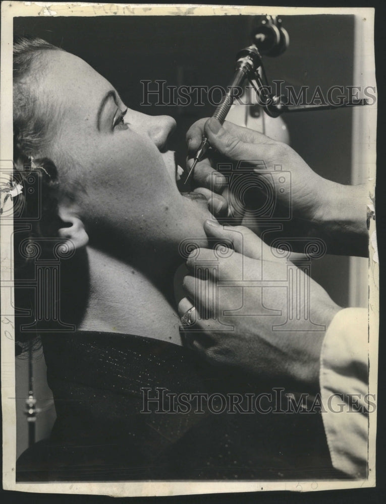 1938 Dentist using a hand strip on patient  - Historic Images
