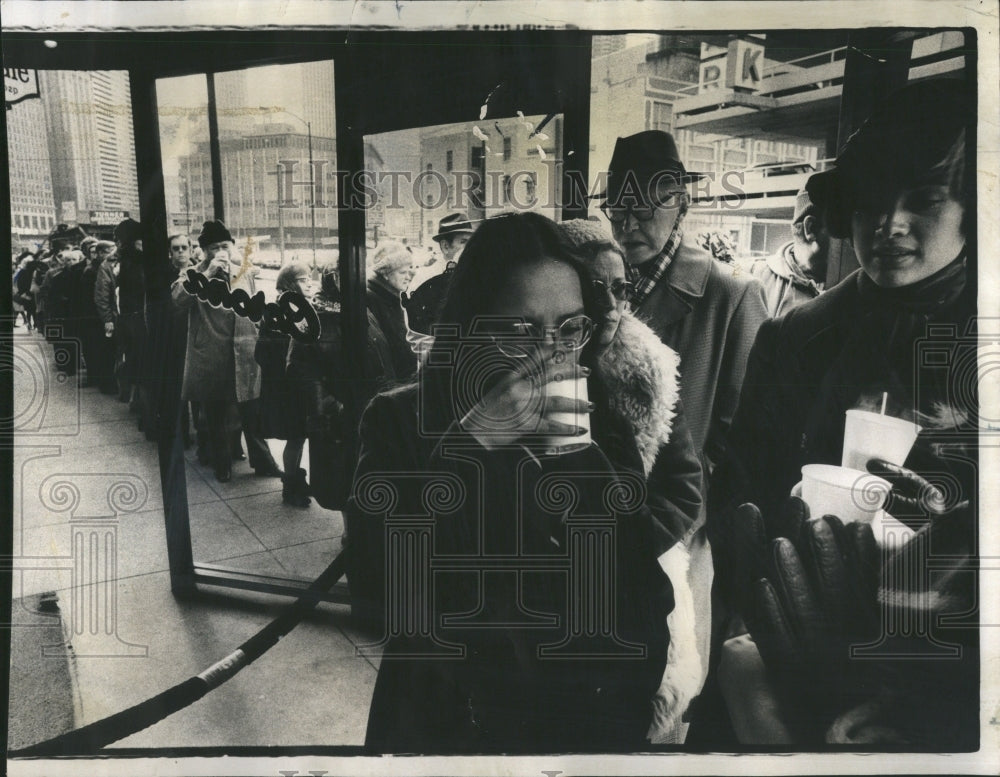 1975 Woman Sips Coffee Waits In Lunch Line - Historic Images