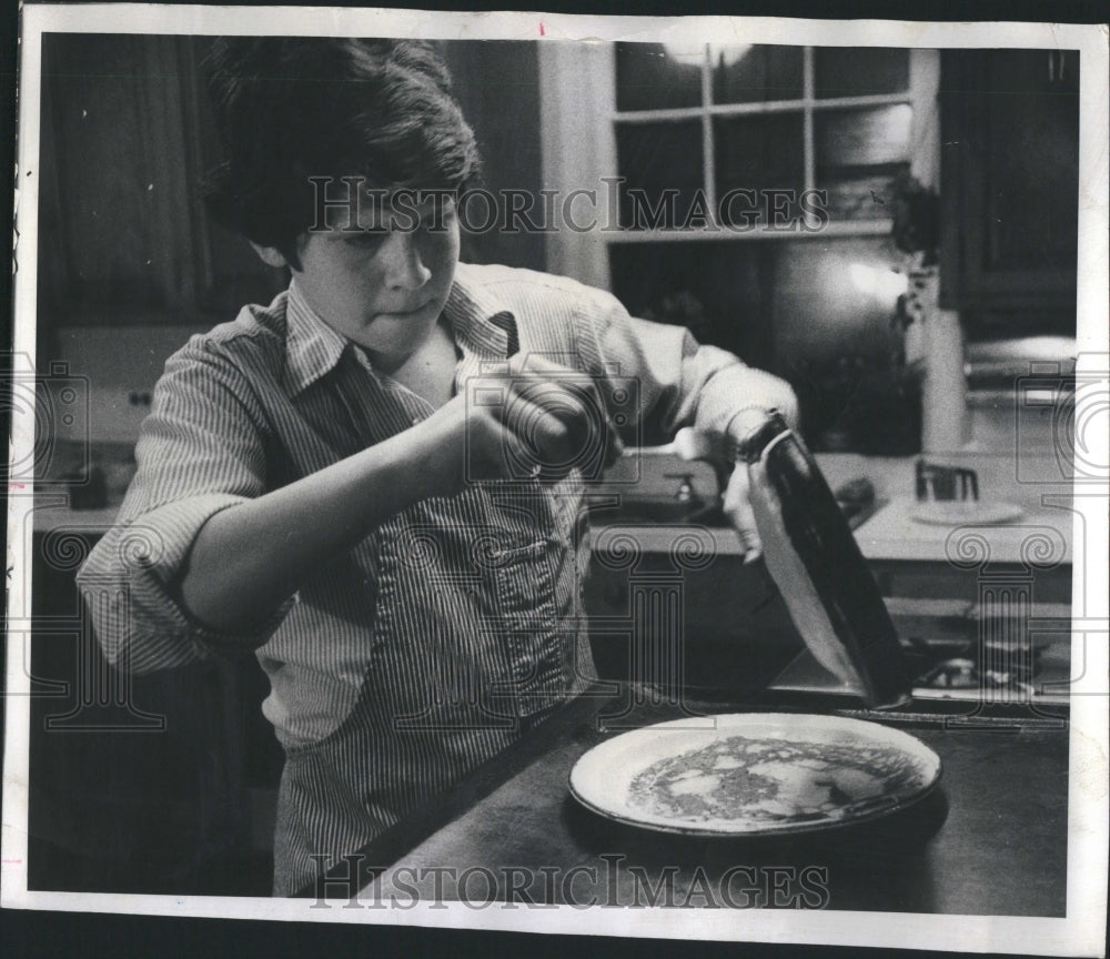 1976 Teen in Apron Cooks Crepe in Kitchen - Historic Images
