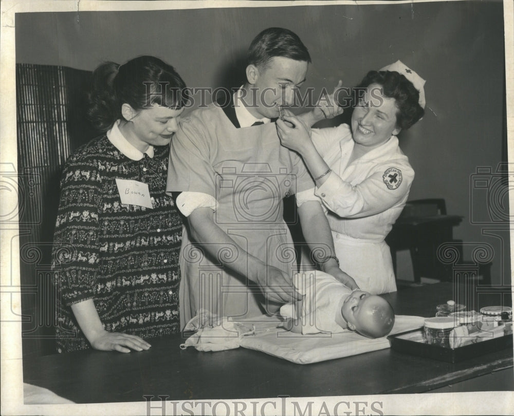 1955 Nurse Teaches Father To Diaper Baby - Historic Images