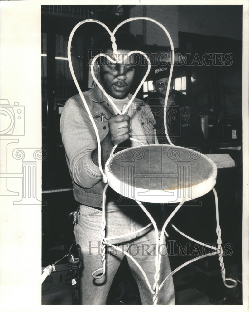 1987 Daniels examines chair for auction - Historic Images