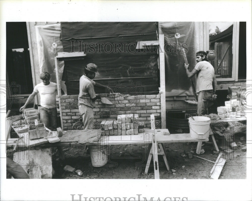 1986 Press Photo Laying bricks man wearing blue