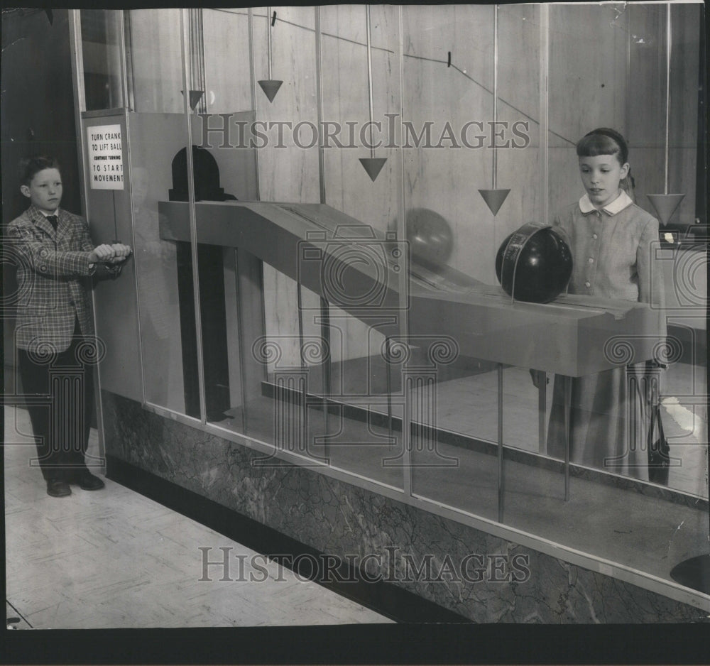 1959 Press Photo Michael Baker turns crank, bowling bal