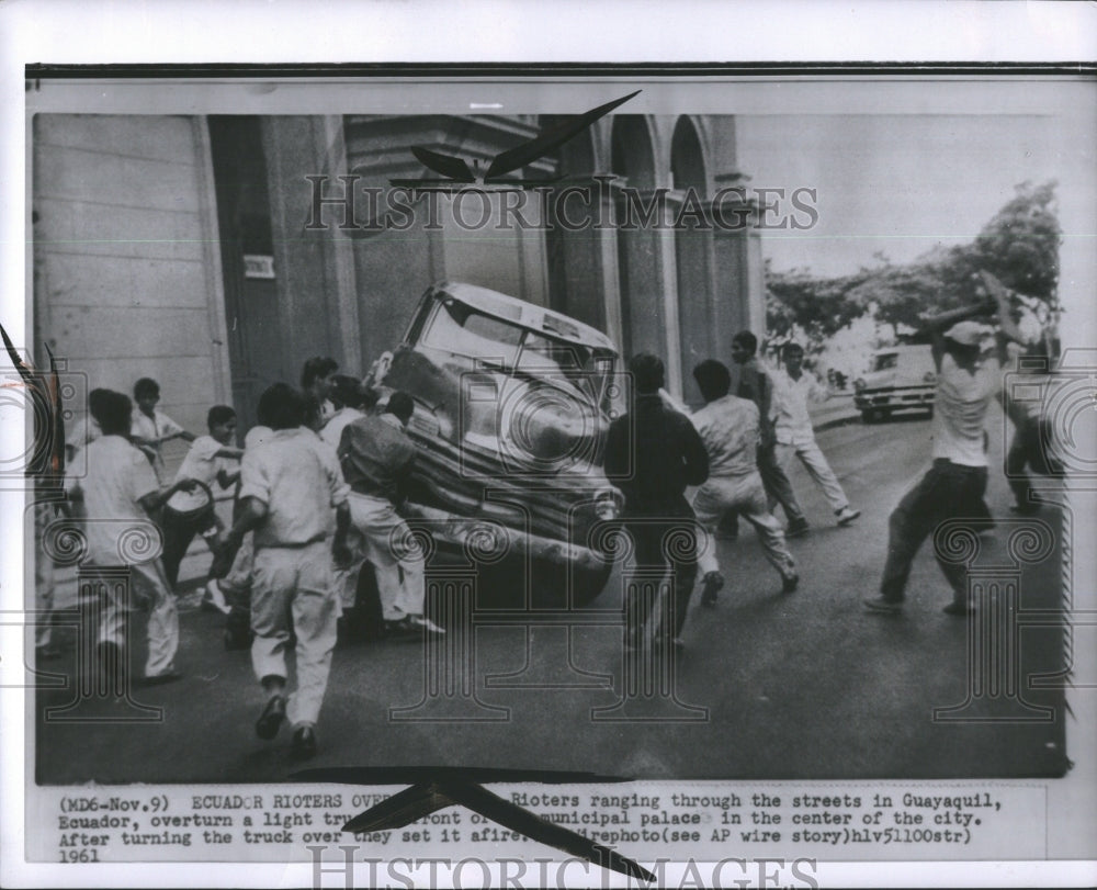 1961 Press Photo Ecuador rioters flipping a car.