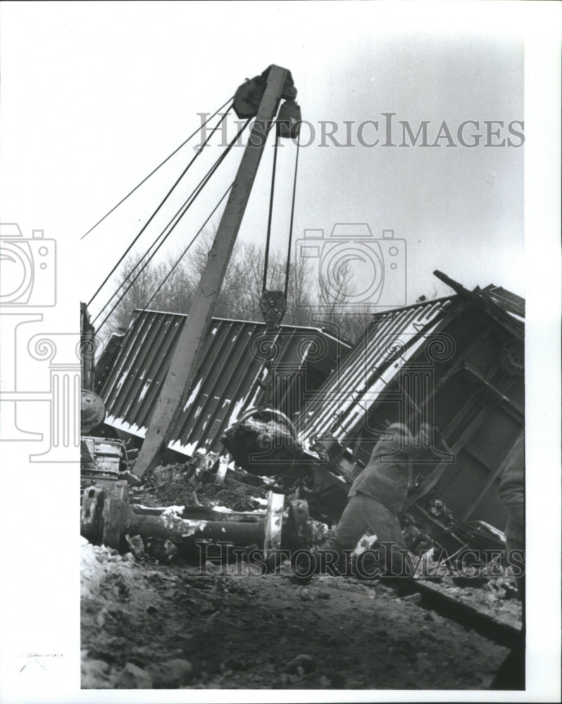 1988 Press Photo Worker attempts to right tipped car