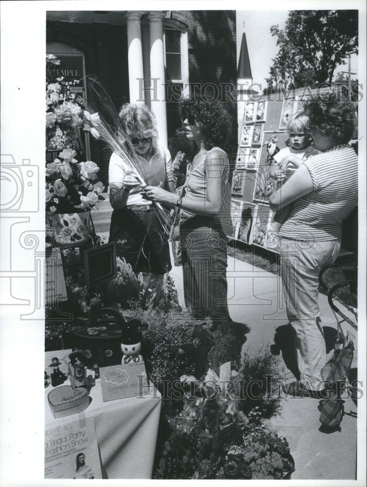 1982 Press Photo Ladies look at feathers, Street Fair