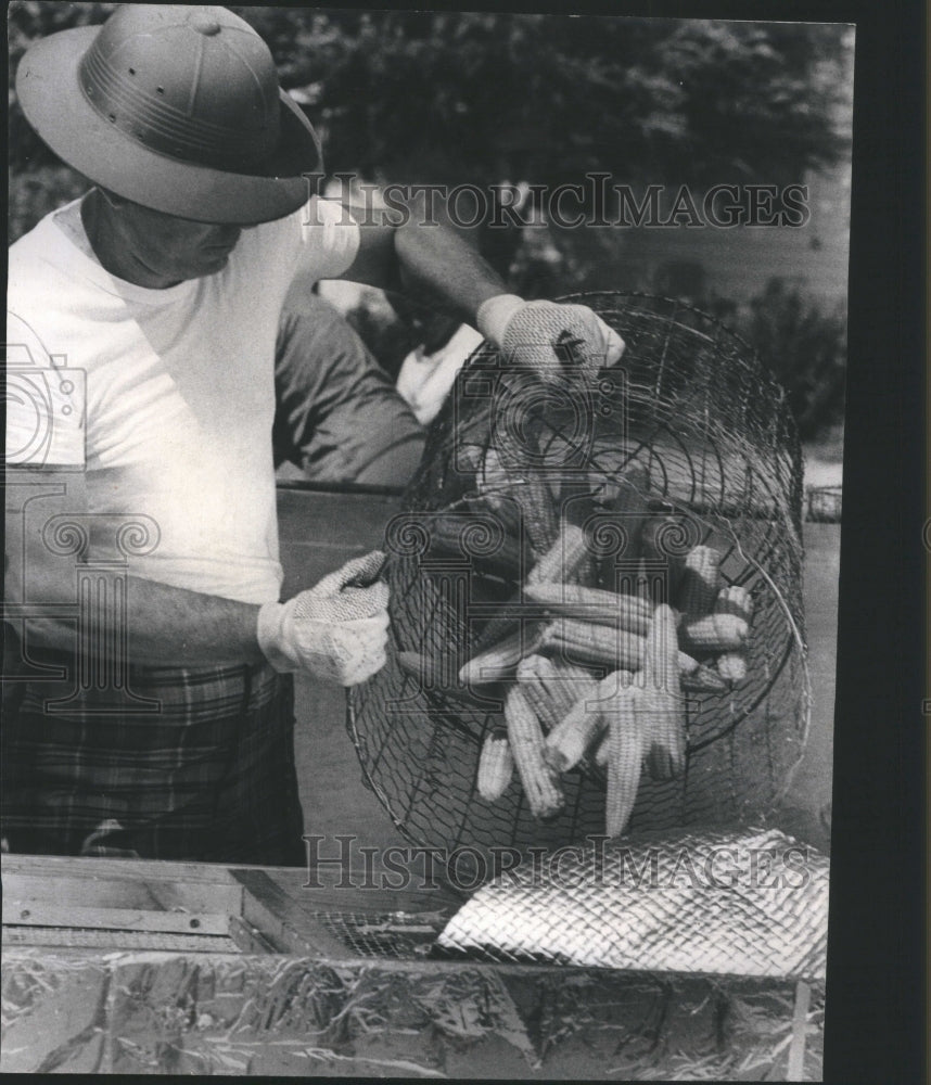 1967 Man dumps corn in foil at Corn Fest  - Historic Images