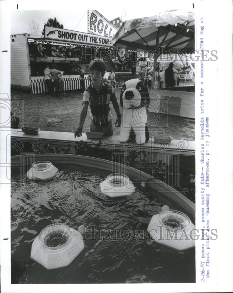 1987 Press Photo Charles Reynolds Dog Float Pitch Game