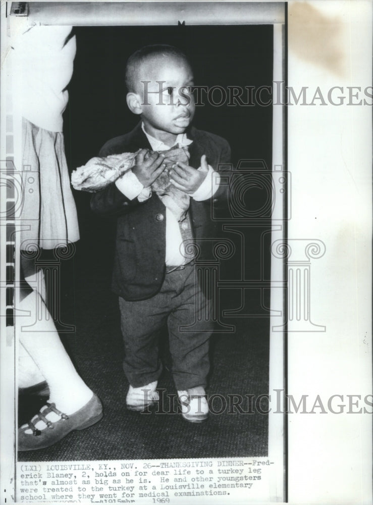 1969 Press Photo Child Carrying Turkey Leg Thanksgiving