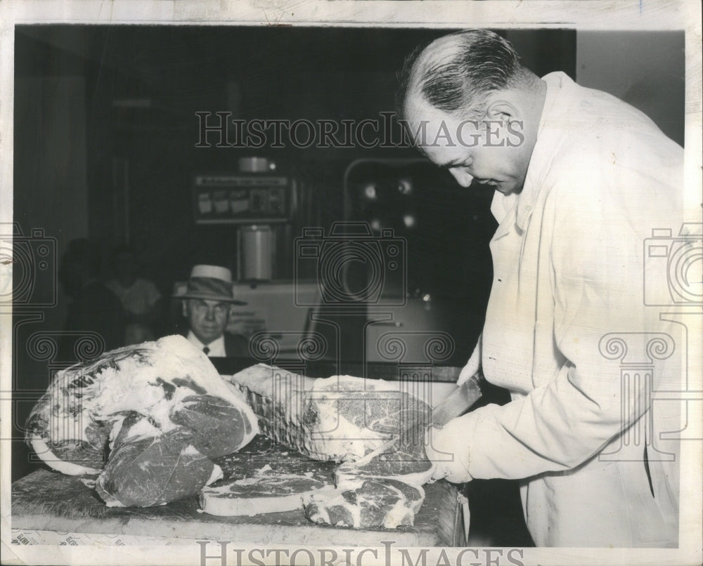 1954 Press Photo Butcher, Sam Sotos cutting raw meat