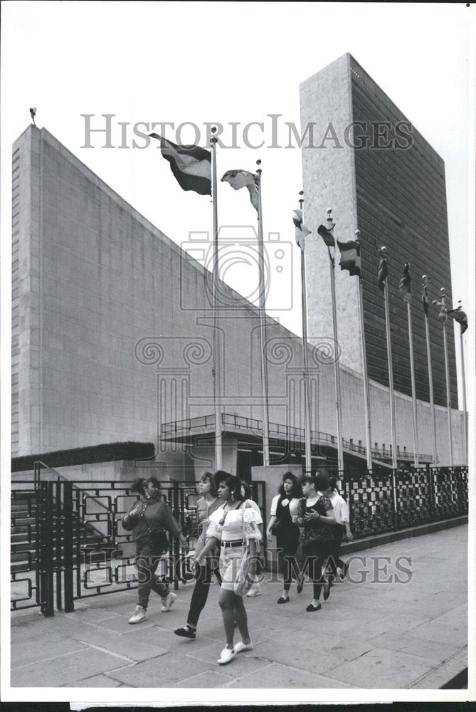 1991 Flagpoles line sidewalk outside U.N. - Historic Images