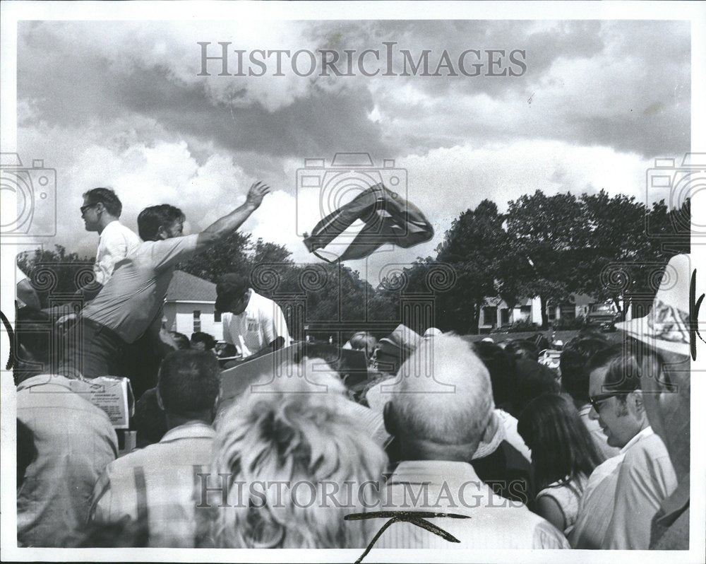 1970 Man throws item into a crowd - Historic Images