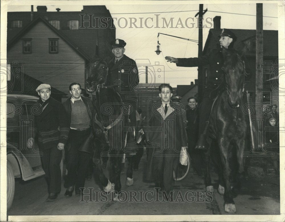 1941 Mounted policemen escort man from work - Historic Images