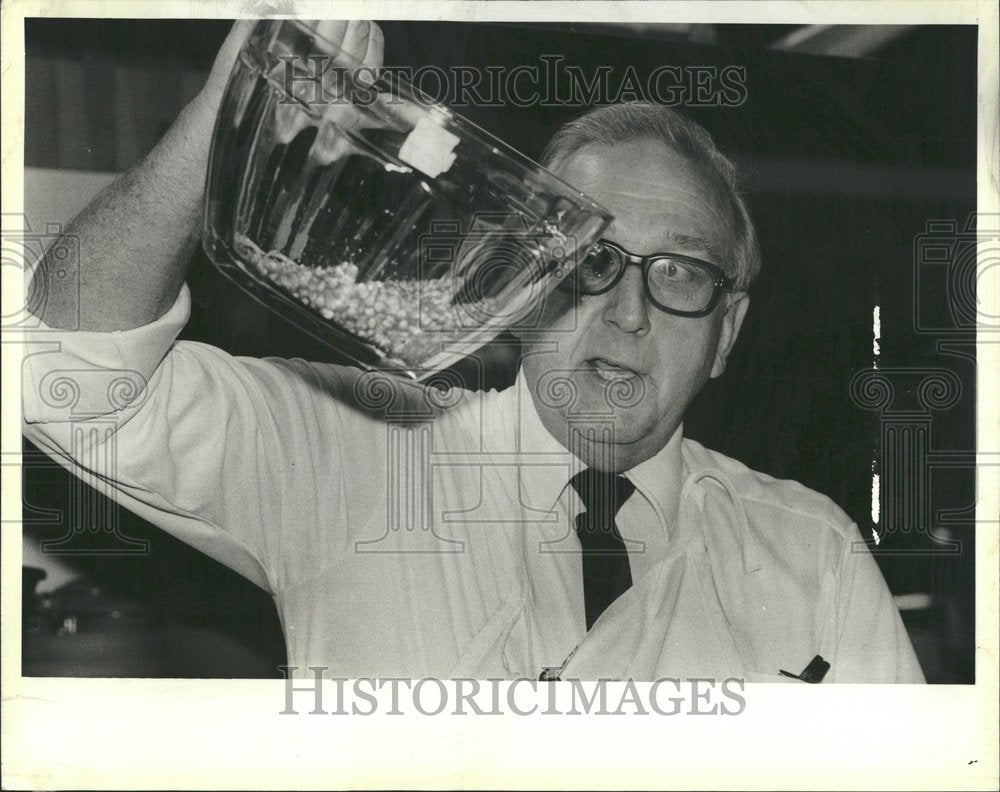 1983 Popcorn promoter examine his kernels - Historic Images