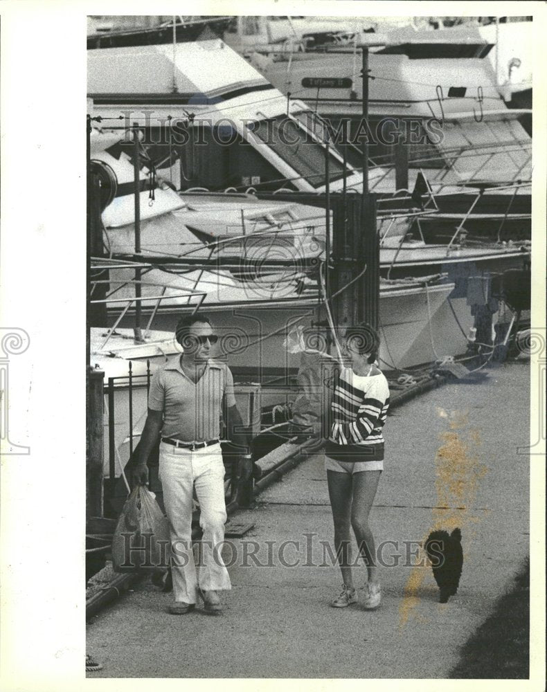 1983 Couple Walks Down Dock With Boats - Historic Images