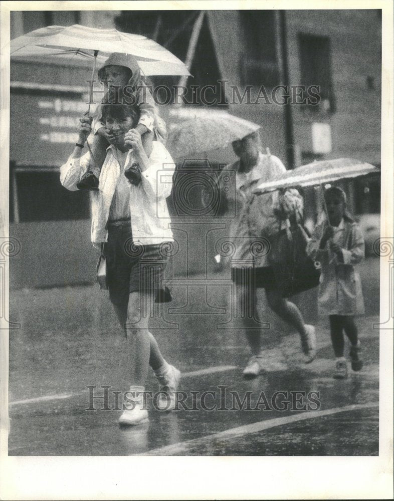 1955 A Family Walking In The Rain - Historic Images