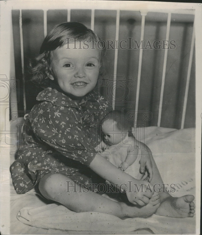 Pamela Lamphere and doll, smiles from crib - Historic Images