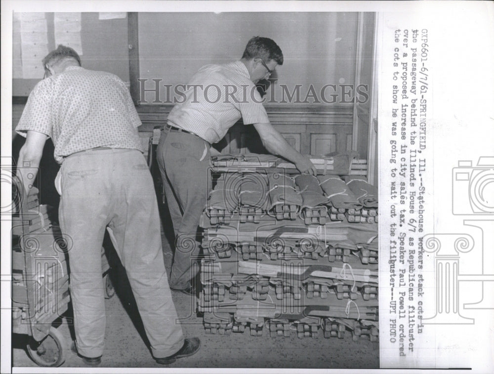 1961 Statehouse workers stack cots. - Historic Images