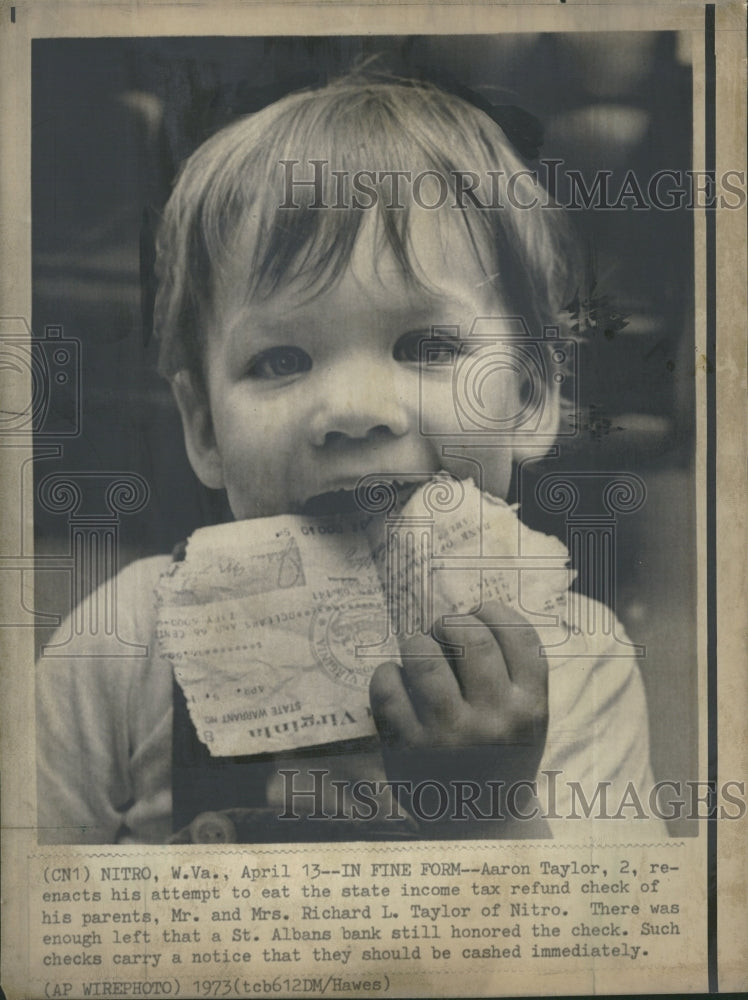 1973 Aarnon Taylor eating income tax check - Historic Images