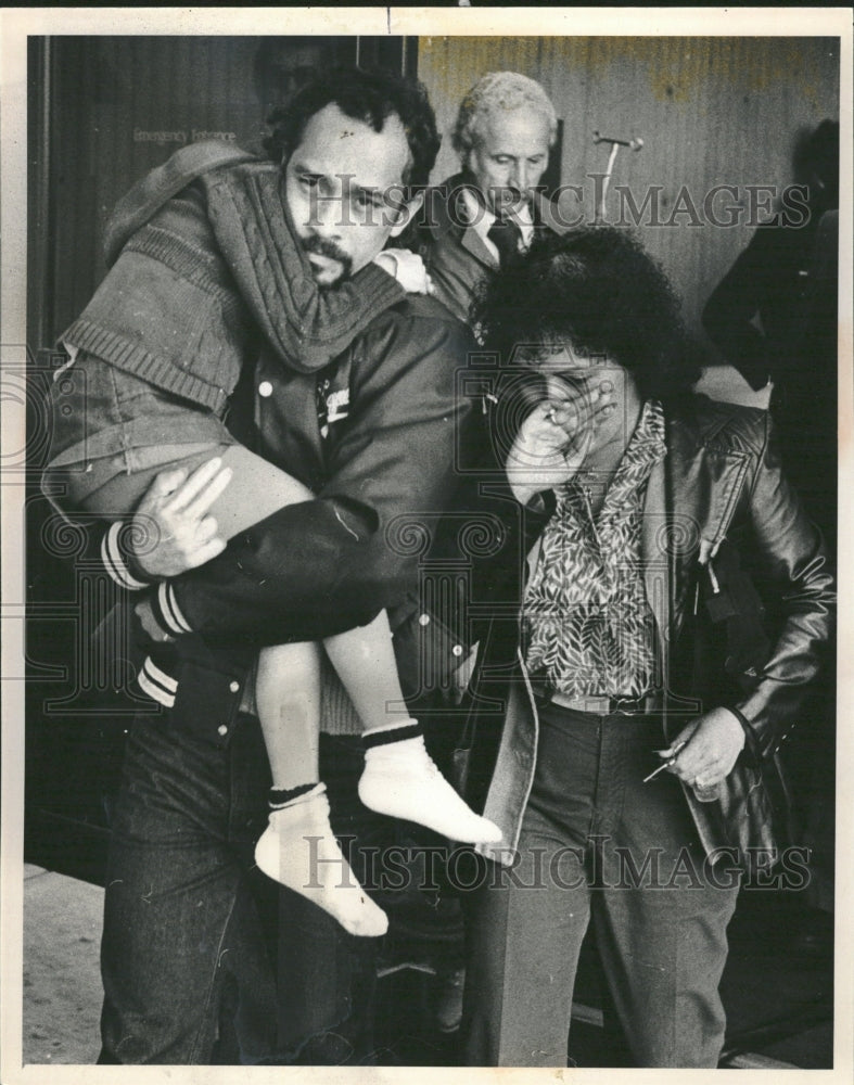 1981 Grim-faced but thankful parents - Historic Images