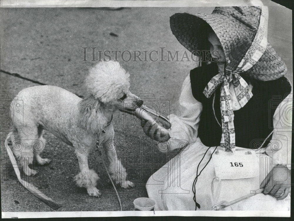 1974 Diane Olson feeds pet poodle Wizard - Historic Images