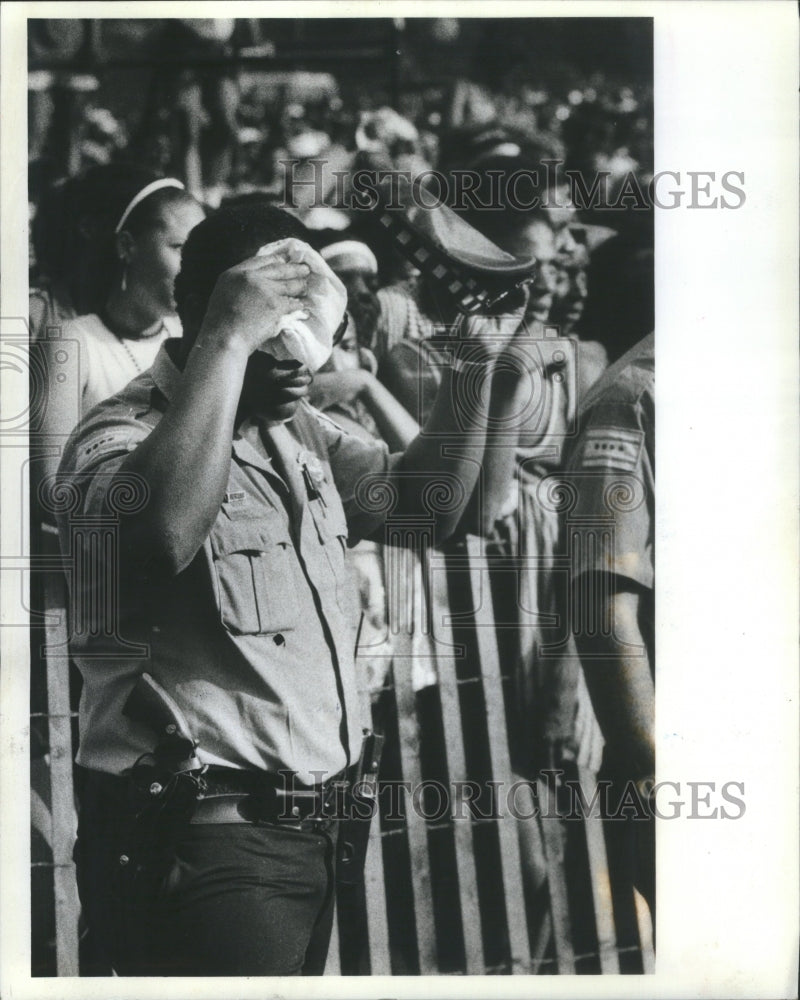 1983, police officer wipes his brow - RRU14337 - Historic Images