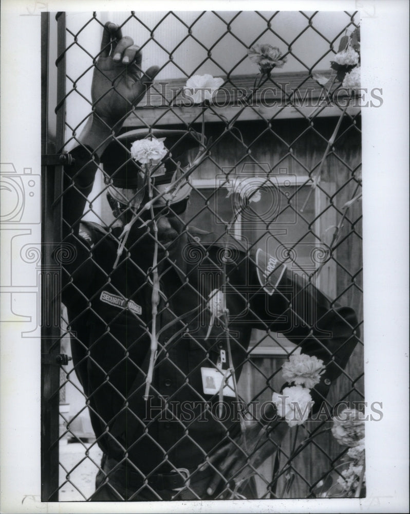 1989, Security Guard Fence Laced Camation - RRU59931 - Historic Images