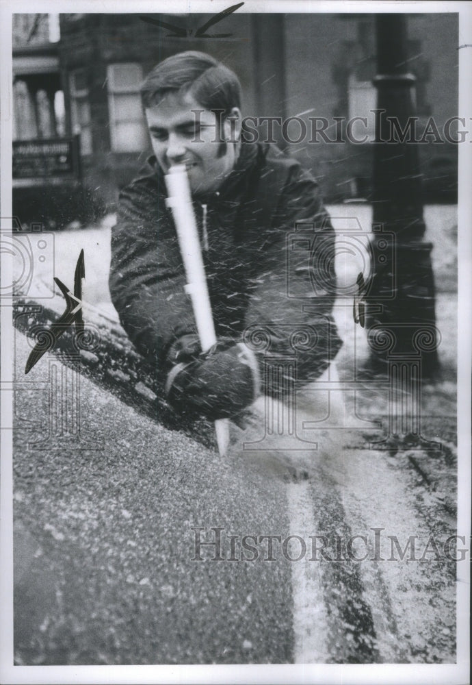 1969 Student scraps hard ice off car window-Historic Images