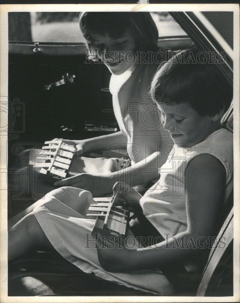 1966 Press Photo Safety belt children trays flip games - RRU76873 - Historic Images