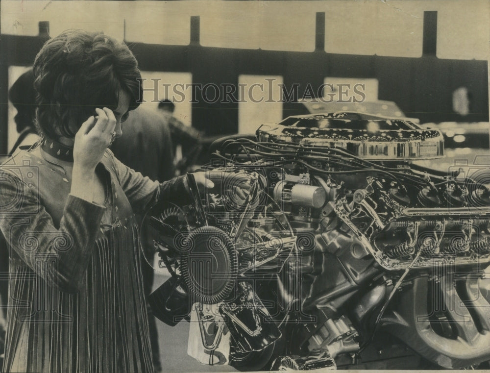 1971 Press Photo Model mystified at mammoth V-8 - Historic Images