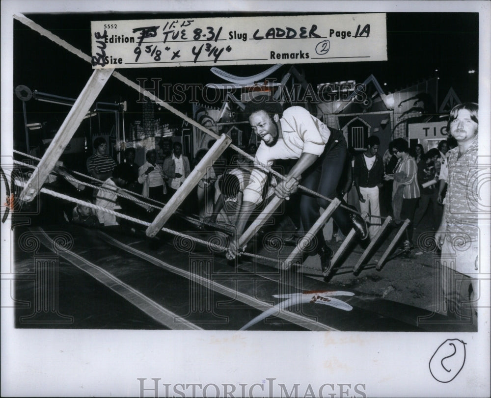 1976 Press Photo Reporter James Kenyon roap ladder try - Historic Images